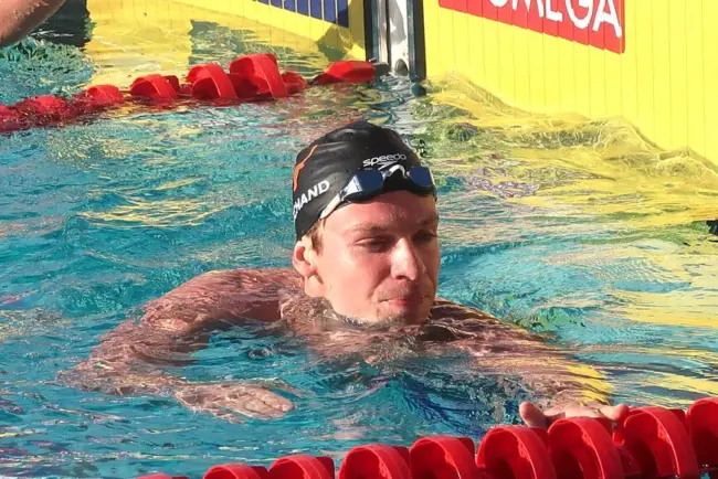 Un groupe de jeunes filles se rassemblent pour un selfie avec Léon Marchand