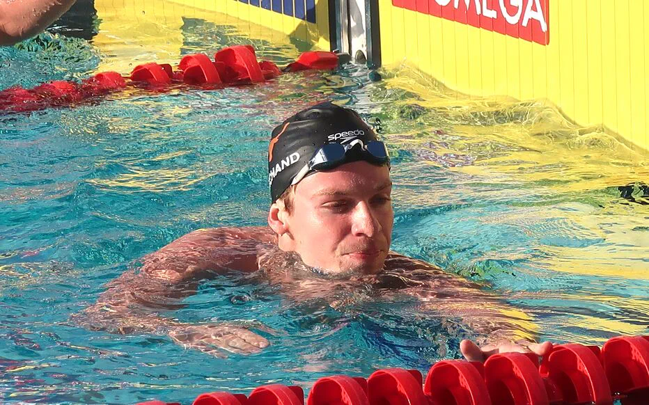 Un groupe de jeunes filles se rassemblent pour un selfie avec Léon Marchand